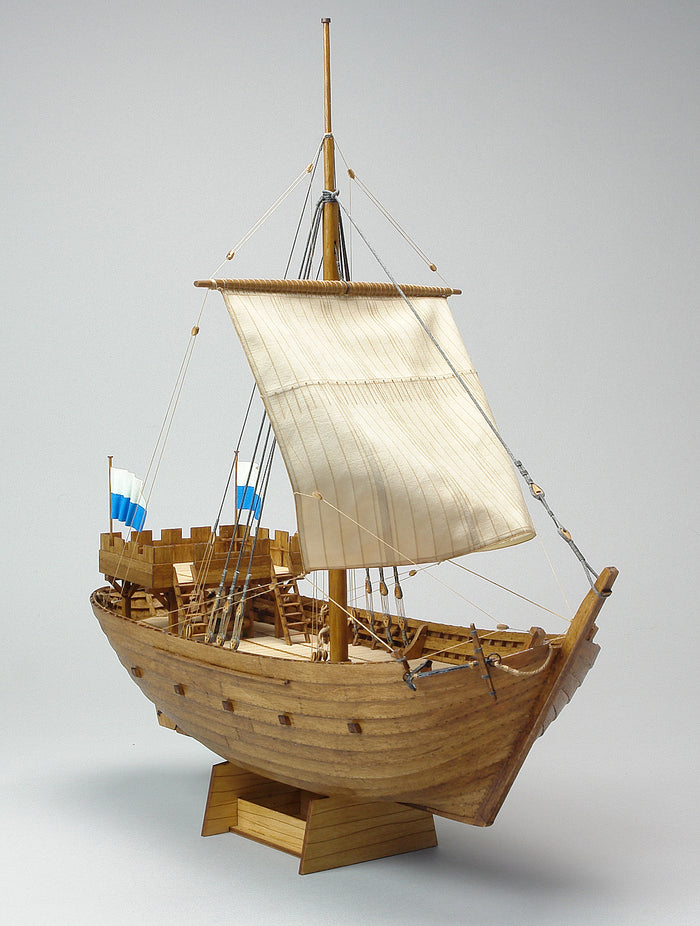 Photo of Kogge von Kampen 1336 model ship kit 1:72 by Shipyard (WM:003) with laser-cut wooden parts, sails, rigging, and painting accessories.